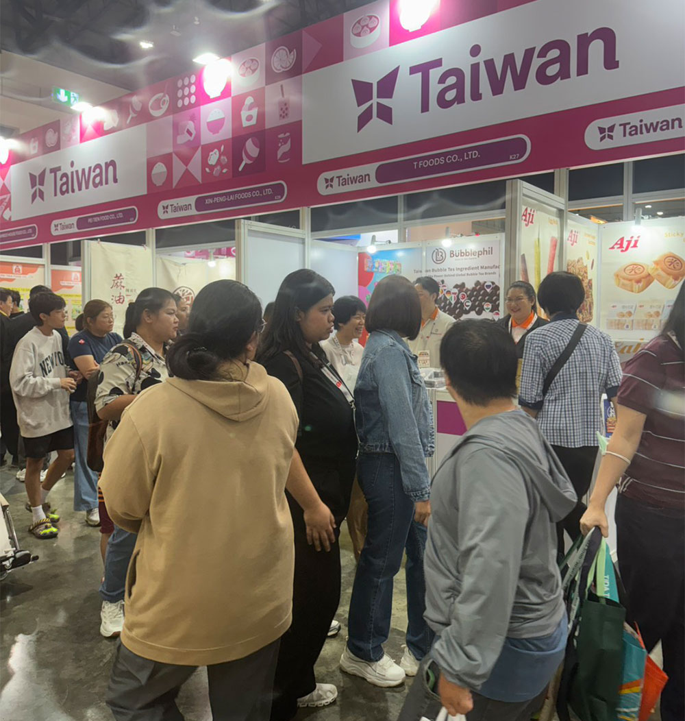 A bustling Taiwan Pavilion exhibition booth at an international food trade show, where the BubblePhil team is consulting with prospective global buyers and hospitality clients.