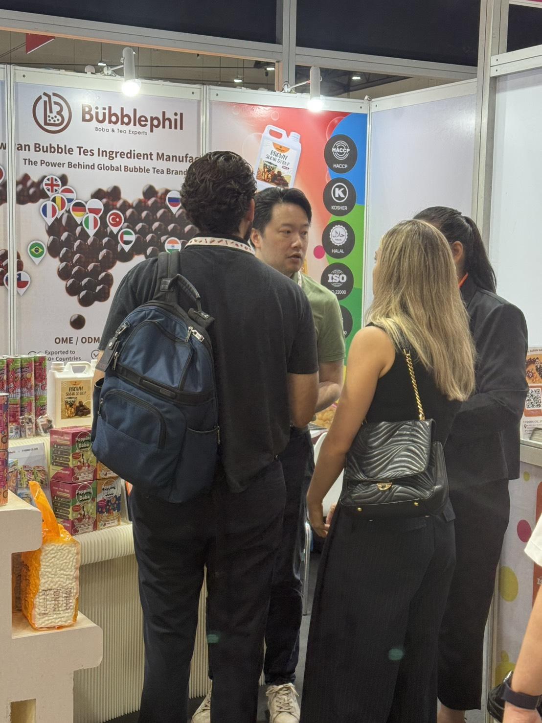 Buyers talking with the BubblePhil team at a trade show booth, with the HACCP, KOSHER, HALAL and ISO 22000 certification marks displayed behind them